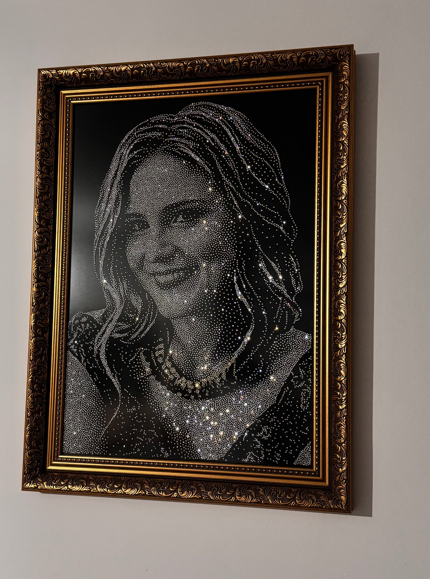Framed portrait of a woman with decorative elements on a white wall