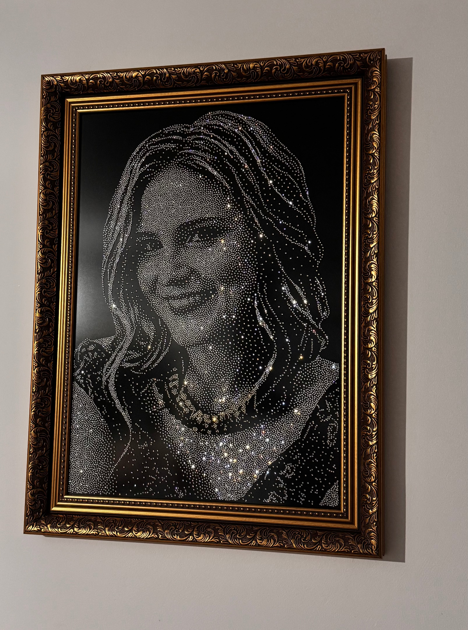 Framed portrait of a woman with decorative elements on a white wall